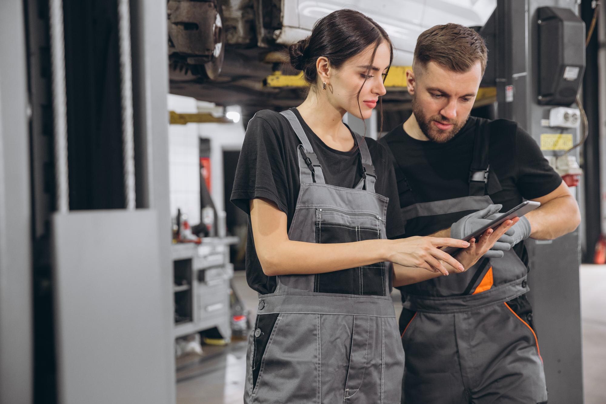 young-expert-female-inspects-repair-checklist-with-automotive-mechanic-worker-partner-quality-suspen.jpg